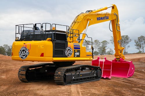 A Komatsu earthmoving machine with a pink coloured digging bucket